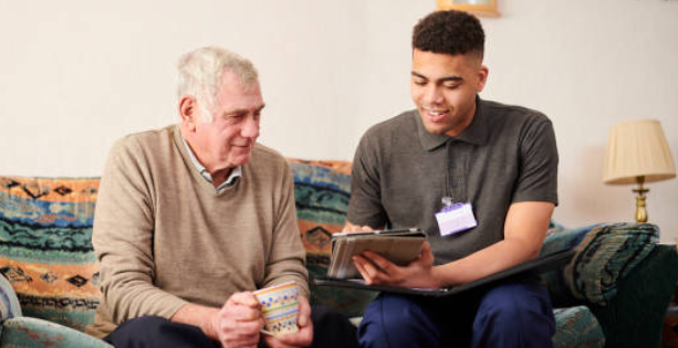 Caregiver assisting a senior with technology and conversation